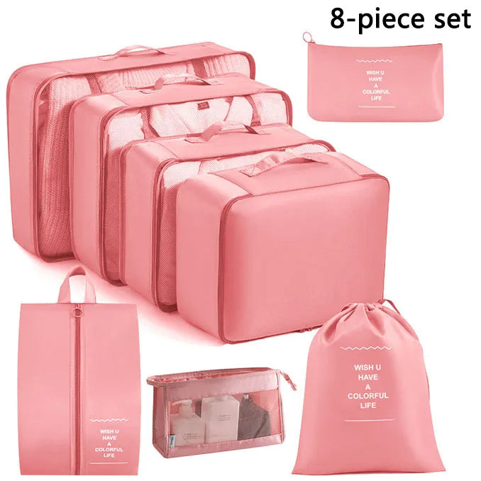 Set of pink travel packing cubes with various sizes on a white background
