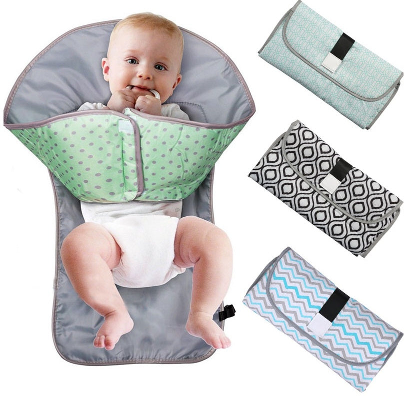 Baby in a green and gray baby wrap with three additional wraps on a white background