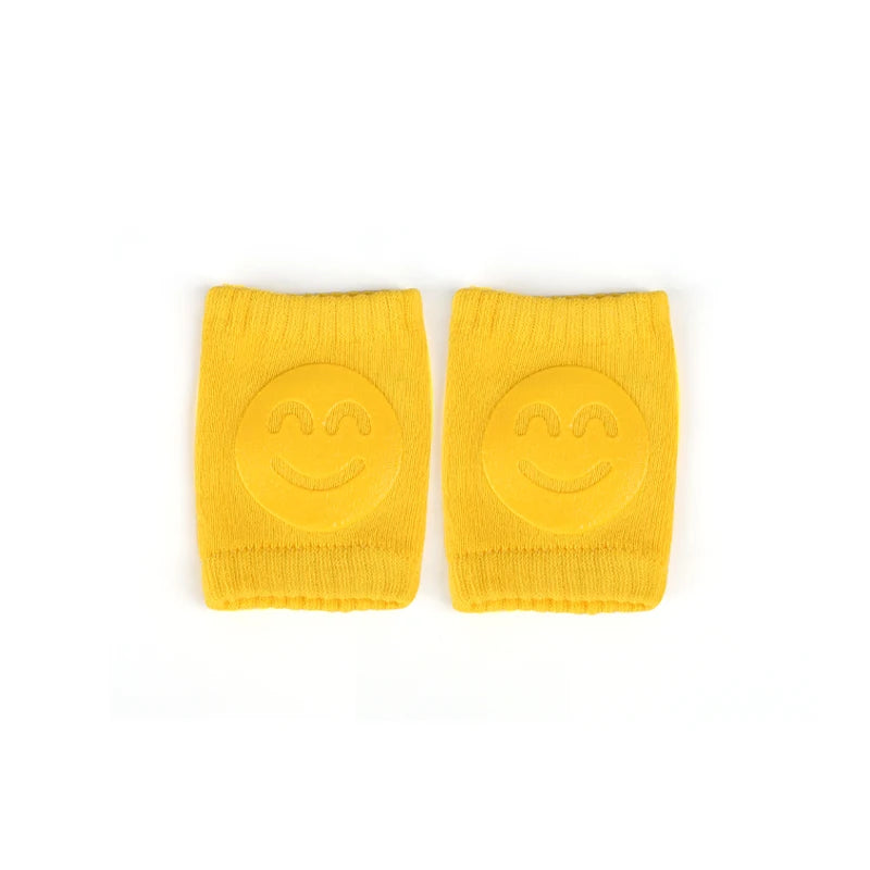 Pair of yellow knee pads with smiley face design on a white background