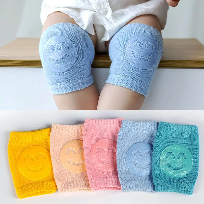 Blue knee pads with smiley face design on a white background, followed by a row of colorful knee pads.