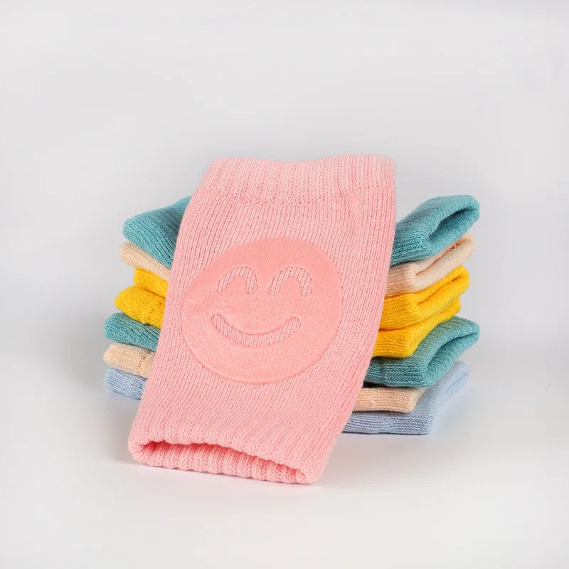 Stack of colorful socks with a smiley face design on a light gray background