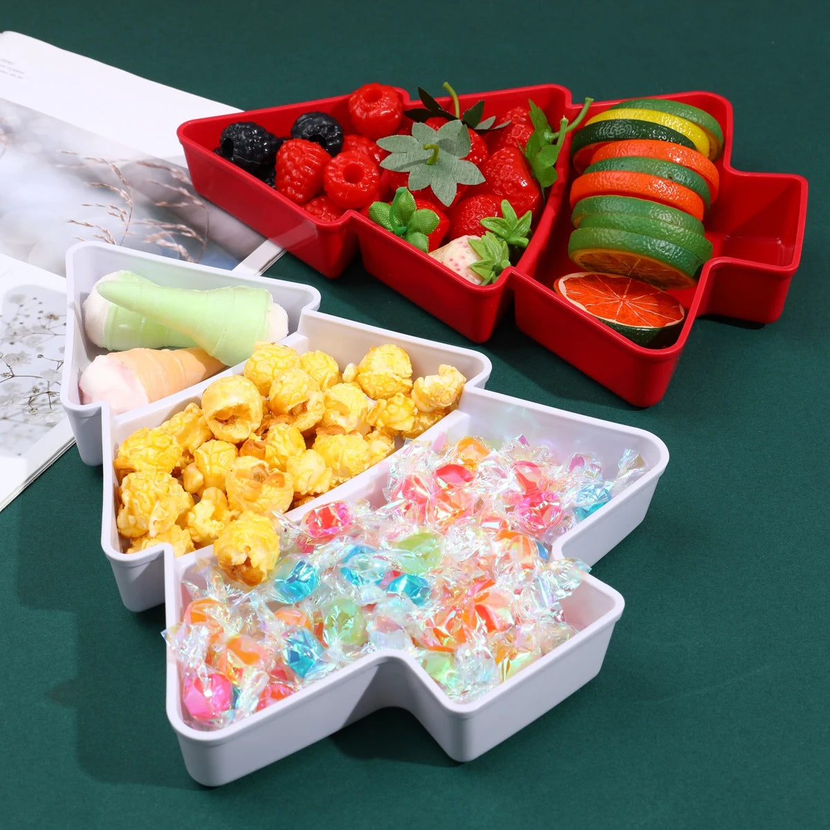 Colorful snack set in a red and white compartmentalized tray on a green surface.